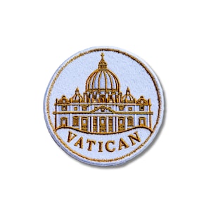 Peut inclure: Un écusson brodé circulaire présentant un fond bleu clair avec une représentation en fil doré de la basilique Saint-Pierre. Le mot VATICAN est brodé en fil doré en arc de cercle le long du bord inférieur de l'écusson circulaire.