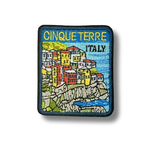 Könnte beinhalten: Ein rechteckiger bestickter Aufnäher mit einer farbenfrohen Landschaft der Cinque Terre in Italien. Das Design zeigt gestapelte gelbe, rote und weiße Gebäude auf felsigen Klippen über blauem Wasser, mit dem gelben Schriftzug CINQUE TERRE ITALY.