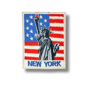 Può includere: Toppa ricamata raffigurante la Statua della Libertà su sfondo della bandiera americana. La toppa ha un bordo bianco e la scritta "NEW YORK" in blu.