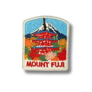 Op de afbeelding: Geborduurde patch met de berg Fuji en een rode pagode. De patch heeft een blauwe luchtachtergrond, met herfstbladeren in tinten oranje, geel en rood. De tekst "MOUNT FUJI" staat onderaan.
