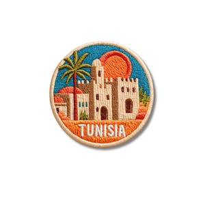 May include: A circular embroidered patch featuring a tan building with arched doorways, a tall palm tree, and a large orange sun against a blue sky. The word TUNISIA is stitched in white capital letters across the orange foreground base.