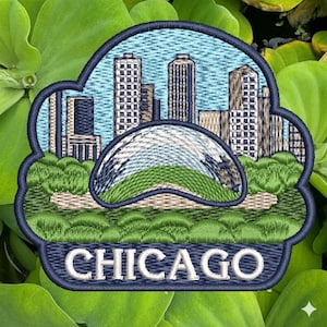 Pode incluir: Patch bordado com o horizonte de Chicago, incluindo a escultura Bean. O patch tem uma borda azul e a palavra "CHICAGO" em branco. O design inclui cores verdes, azuis e bege, em um fundo de folhas verdes.