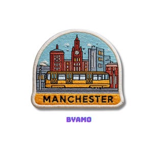 May include: Embroidered patch featuring a yellow tram and Manchester skyline against a blue sky. The patch includes the word "MANCHESTER" in yellow and the word "BYAMO" in purple.