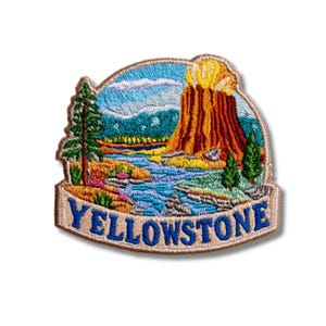 May include: An embroidered patch featuring a landscape of Yellowstone National Park. The design includes a geyser erupting with orange and yellow tones, a blue river, green pine trees, and a light blue sky. The word YELLOWSTONE is in blue text.