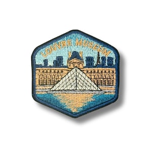May include: A hexagonal embroidered patch featuring the Louvre Museum with its iconic glass pyramid. The design uses shades of blue, tan, and gold thread, with the text LOUVRE MUSEUM arched in gold at the top against a light blue sky background.