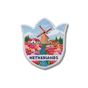 May include: A tulip-shaped embroidered patch featuring a landscape of a brown windmill, white houses with red roofs, and a field of colorful pink, orange, and yellow tulips. A blue stream runs through the center, and the word NETHERLANDS is stitched in blue.