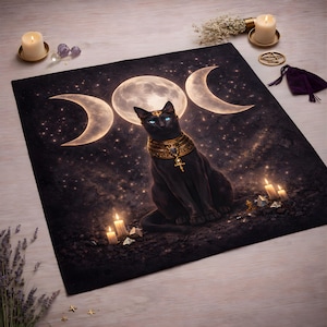 May include: A black cat with blue eyes and gold jewelry sits on a dark mat with a celestial design. The mat features a full moon, crescent moons, and stars. Lit candles and crystals surround the cat, creating a mystical scene.
