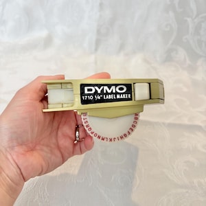 Retro Dymo Hobbyist 1710 Label Maker, measuring 3” x 5” x 5.5” in Very Well Loved Working Condition, Refills not Included. Classic Beige