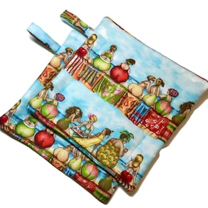 Może przedstawiać: Dwa niebieskie uchwyty do garnków z kolorowym wzorem kobiet w strojach kąpielowych i tropikalnych owoców. Uchwyty mają pętlę po obu stronach.