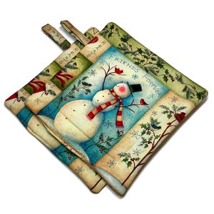 May include: Three square quilted pot holders with a winter theme. Each pot holder features a different design, including a snowman with a red and white scarf, birds, and the words "Friends Forever". The pot holders have green and blue borders.