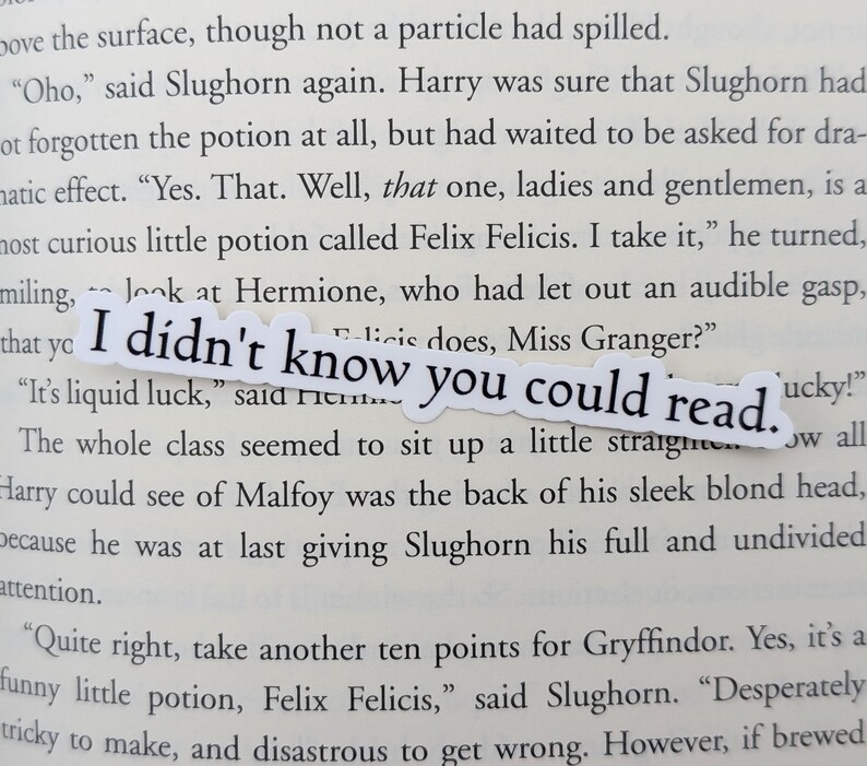May include: A white sticker with the text "I didn't know you could read." The sticker is placed on a page of a book with text about a potion called Felix Felicis.