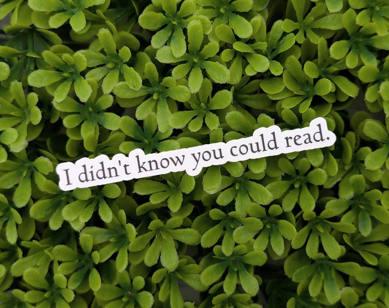 May include: White sticker with the text "I didn't know you could read." on a green leafy background.