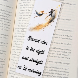 Peut inclure: Marque-page rectangulaire blanc avec l'inscription "Second star to the right and straight on 'til morning" en noir. Il présente une illustration à l'aquarelle de deux personnages dansant, avec une traînée dorée et des étoiles.