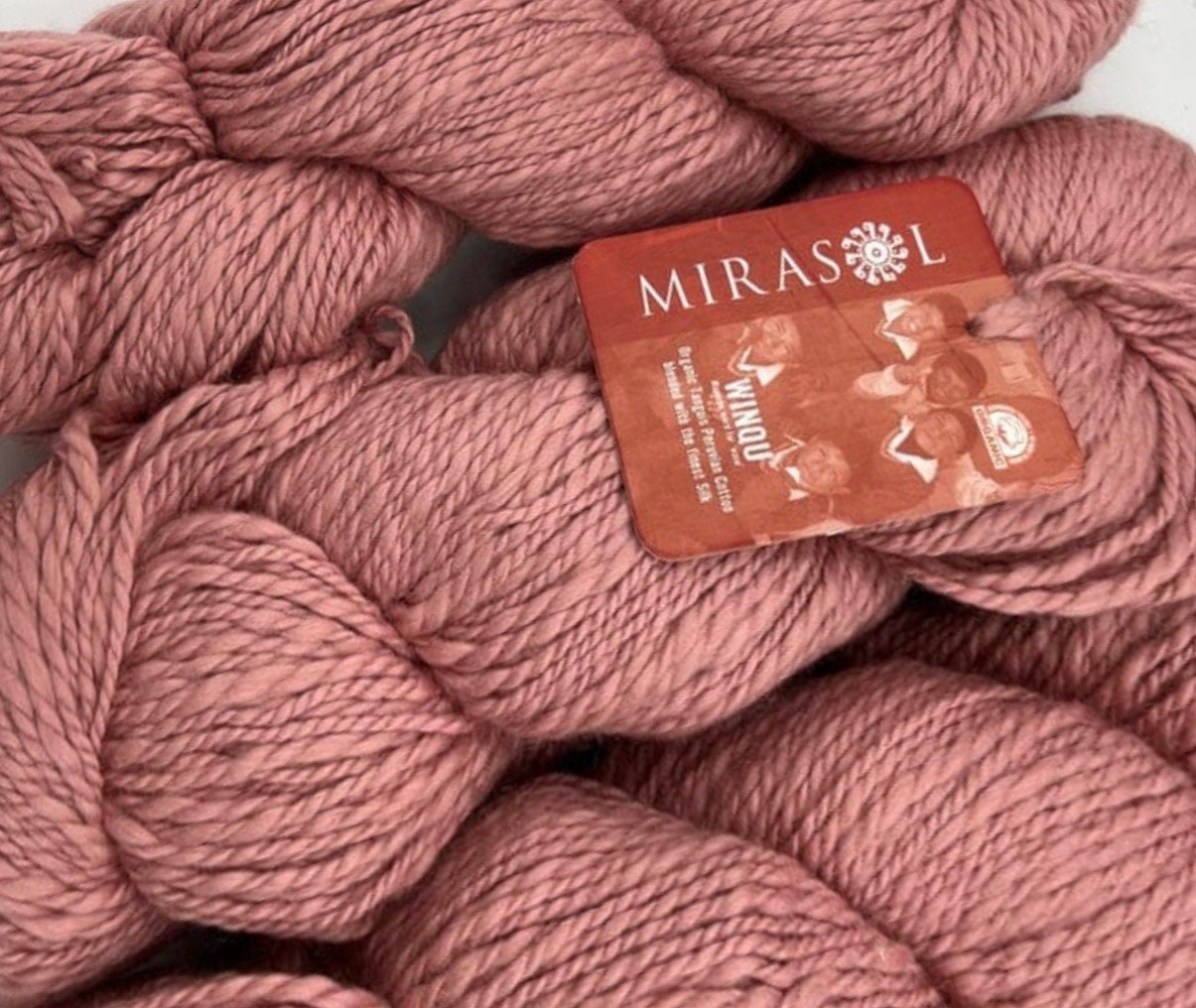 Hand-dyed cotton thick and thin yarn, 525 yard skeins, in shades of red,  pink, beige, and brown