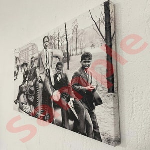 May include: Monochrome canvas print showing a group of young people in suits posing on and around a vintage car. The scene is set outdoors with trees and a building in the background. The car has a visible license plate.