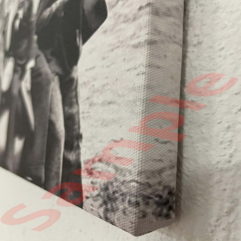 May include: Monochrome canvas print featuring a person in a coat. The canvas is stretched over a wooden frame, with the edges in view. The image is a close-up, highlighting the texture of the canvas and the artwork's details.