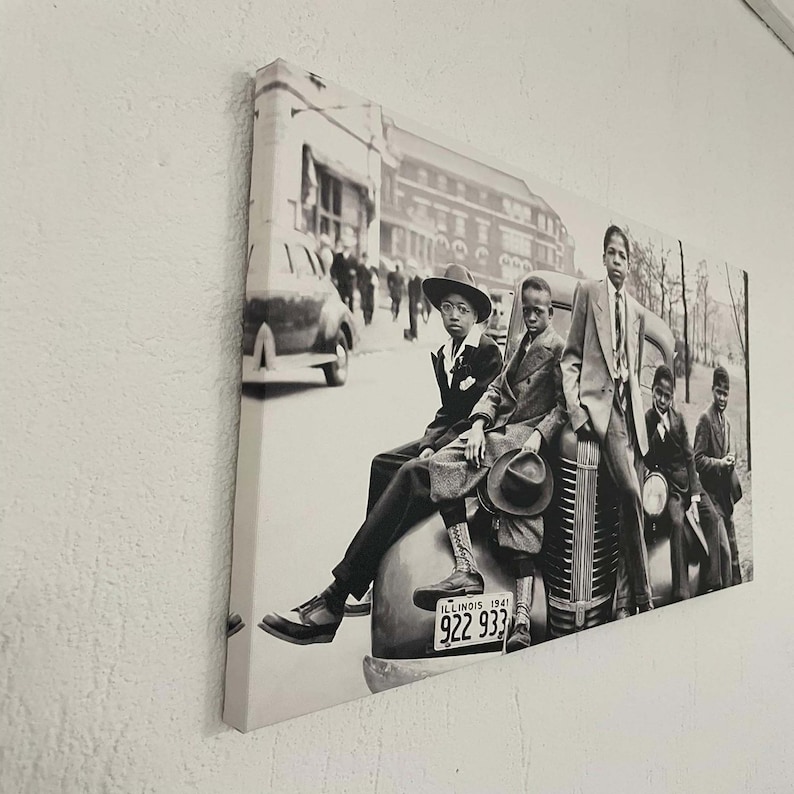 May include: Monochrome canvas print depicting a vintage photograph of young people posing with a classic car. The image is set in an urban environment, with a street and buildings in the background. The license plate reads "ILLINOIS 1941".