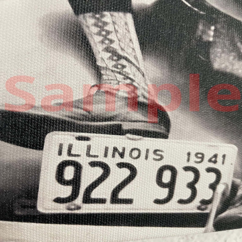 May include: Monochrome image featuring an Illinois license plate from 1941, with the registration number 922 933. A leg and boot are partially visible in the shot.
