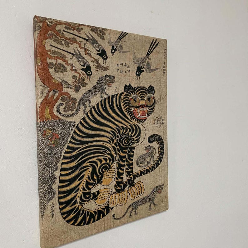 May include: Canvas art print featuring a stylized tiger with black stripes and yellow accents, surrounded by other tigers and birds. The artwork has a vintage aesthetic with a beige background and a touch of red.