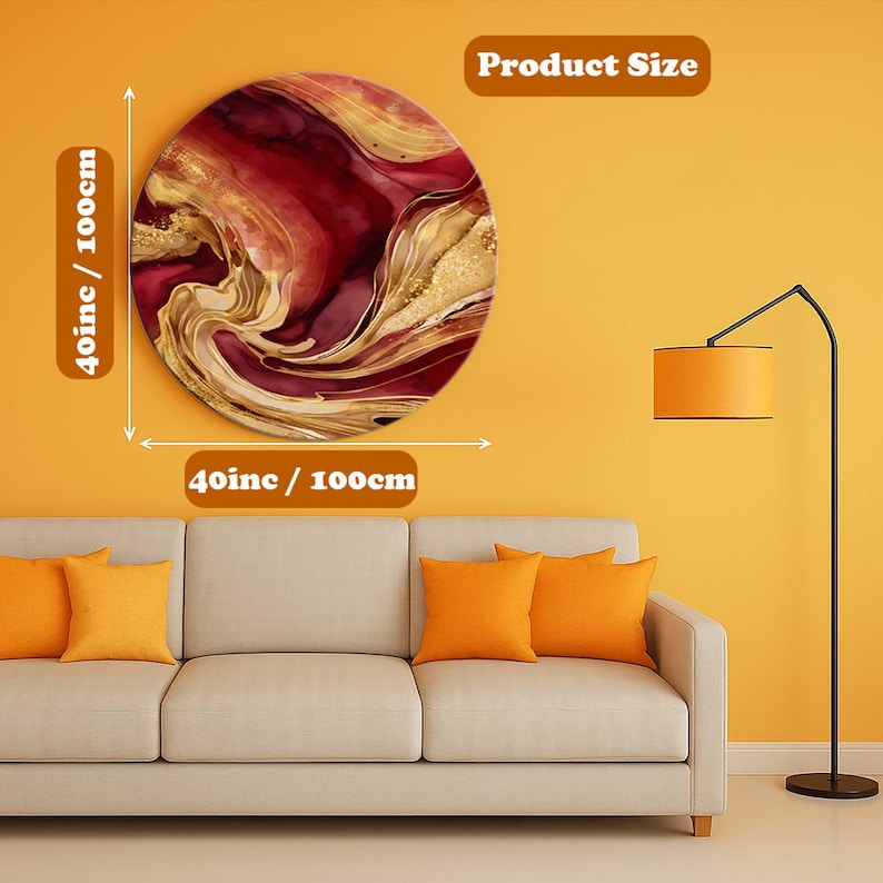 Op de afbeelding: Een ronde wandkunst met een wervelend ontwerp in tinten rood, goud en wit. Het kunstwerk heeft een diameter van 100 cm (40 inch) en hangt aan een gele muur boven een beige bank met oranje kussens.