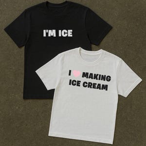 Könnte beinhalten: Zwei kurzärmelige T-Shirts. Eines ist schwarz mit dem Text "I'M ICE" in Weiß. Das andere ist weiß mit dem Text "I ♥ MAKING ICE CREAM" in Schwarz, mit einem rosa Herzsymbol.