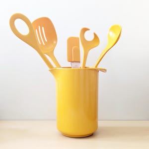 Yellow vintage 1970s Rosti Mepal Denmark utensils and pitcher.
