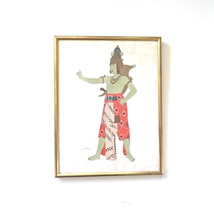 May include: Framed artwork featuring a stylized illustration of a figure in traditional attire. The figure has green skin, a crown, and a red and white patterned skirt. The artwork is in a gold frame.