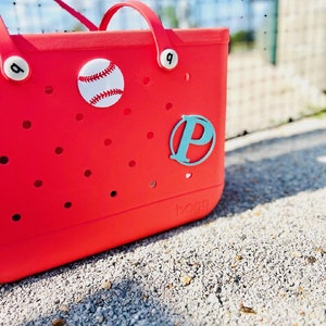 May include: Red tote bag with a white baseball and a turquoise letter "P" on the front. The bag has a white logo that says "BOGO" on the bottom.