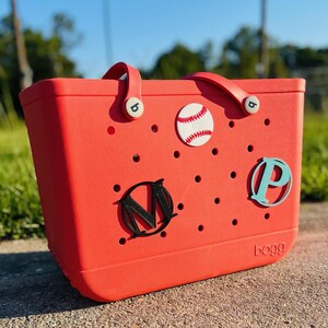 May include: Red tote bag with a baseball, "M" and "P" letters, and the word "bogg" printed on the bottom.
