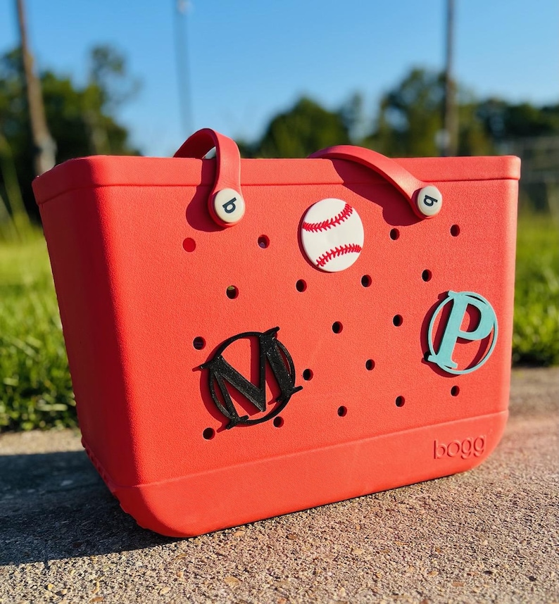 May include: Red tote bag with a baseball, "M" and "P" letters, and the word "bogg" printed on the bottom.