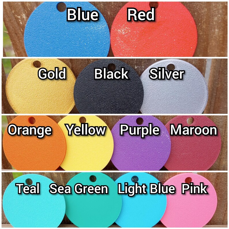 May include: A collection of 12 round, flat, painted discs in various colors, including blue, red, gold, black, silver, orange, yellow, purple, maroon, teal, sea green, light blue, and pink. Each disc has a different color and is labeled with the color name.