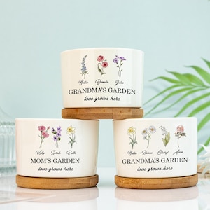 May include: Three white ceramic flower pots with bamboo bases. Each pot features a different floral design and the text "Grandma's Garden love grows here" or "Mom's Garden love grows here".