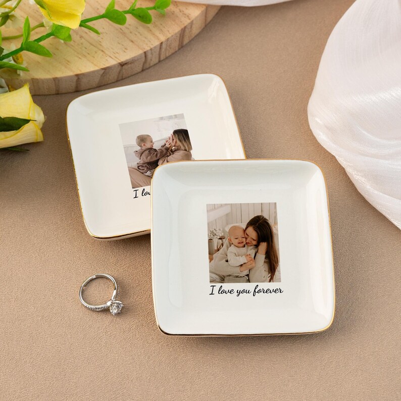 Puede incluir: Dos platos cuadrados de cer&aacute;mica blanca con borde dorado. Cada plato tiene una foto de una madre y un ni&ntilde;o. El plato superior tiene el texto "I love" y el plato inferior tiene el texto "I love you forever".