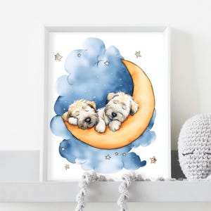 May include: A framed print featuring two sleeping puppies nestled on a crescent moon. The illustration has a soft color palette with a blue cloud background, golden moon, and small star accents. The puppies are light brown with closed eyes.