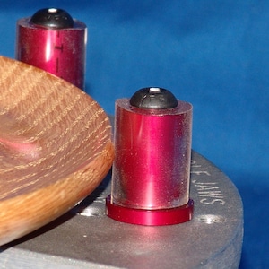 May include: Two red and clear plastic turning tools with black tops. The tools are mounted on a silver metal base with the word "Jaws" printed on it.