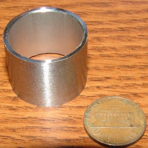 May include: A silver metal ring with a smooth, brushed finish. The ring is about the size of a US penny.