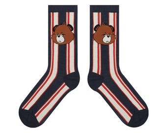 May include: A pair of navy blue socks with red and white vertical stripes. Each sock features a brown bear face at the top. The socks are designed for comfort and style, suitable for everyday wear.
