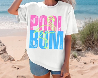 May include: White t-shirt with a pink and blue graphic that says "POOL BUM" with a flamingo illustration in the middle.