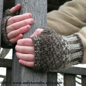 May include: A pair of brown and white fingerless gloves with a knitted pattern. The gloves are made of wool and have a warm, cozy look.