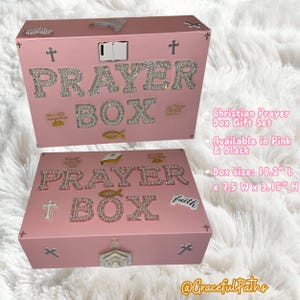 Op de afbeelding: Roze gebedsdoos met het woord "PRAYER BOX" in strass letters. De doos heeft kruis- en visversieringen en de tekst "Prayer changes things". Afmetingen doos: 26 cm L x 19 cm B x 8 cm H.