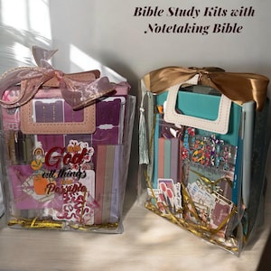 Puede incluir: Dos bolsas transparentes llenas de útiles de estudio bíblico, que incluyen una Biblia para tomar notas, pegatinas y blocs de notas. Las bolsas están atadas con cintas e incluyen el texto "Dios, todas las cosas posibles".