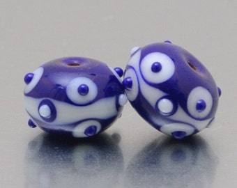 Lampwork glass beads, earring pair. Faces in dark blue and white, by Jennie Yip