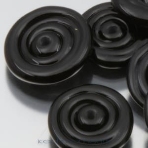 May include: A close-up of black glass buttons with a concentric circle design. The buttons are smooth and shiny.