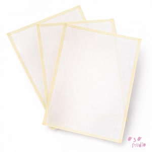 May include: Three off-white rectangular sheets with a light yellow border. The sheets are slightly overlapping, creating a layered effect. The background is plain white, highlighting the sheets' texture and design. The sheets are likely for crafting or art projects.