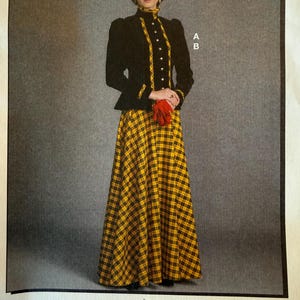 May include: A long-sleeved black jacket with a high collar and a central yellow and black plaid panel featuring buttons, paired with a matching floor-length yellow and black plaid skirt. A red beret and red gloves are worn with the outfit.