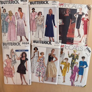 May include: A collection of six vintage sewing pattern envelopes from Butterick and McCall's, featuring various dress designs including long gowns, cocktail dresses, and midi-length styles with diverse necklines, sleeve lengths, and floral or solid patterns.