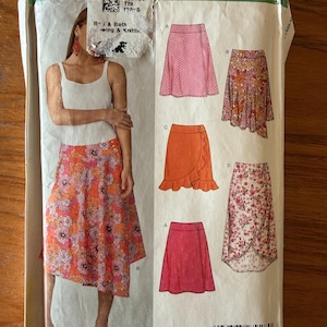 May include: A New Look sewing pattern envelope featuring a woman wearing a floral skirt. The envelope displays illustrations of wrap skirts in various colors and patterns, including pink, orange, and floral designs. The text "New Look" is visible.