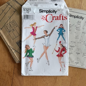 May include: A Simplicity 9321 Crafts sewing pattern envelope for ice skating outfits in size AA. The white envelope features illustrations of five different skating costumes in pink, white, teal, green, and red, along with technical line drawings.