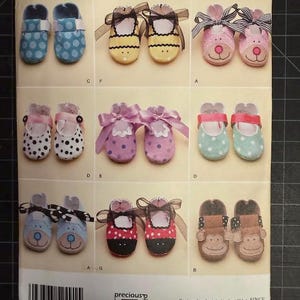 May include: Simplicity pattern featuring various baby shoe designs. The shoes include polka dots, animal faces, and bows. The pattern is labeled with sizes XS-L and includes the text "precious patterns".