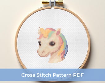 Puede incluir: Un patrón de punto de cruz de la cabeza de un unicornio, con un cuerpo color crema y una melena con colores arcoíris pastel. El diseño está dentro de un bastidor de bordado de madera. El texto "Cross Stitch Pattern PDF" se muestra en una pancarta azul.